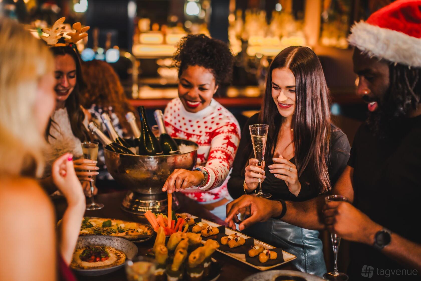 An event venue with a festive buffet and champagne setup in the Ruby semi-private area at Puttshack Lakeside.