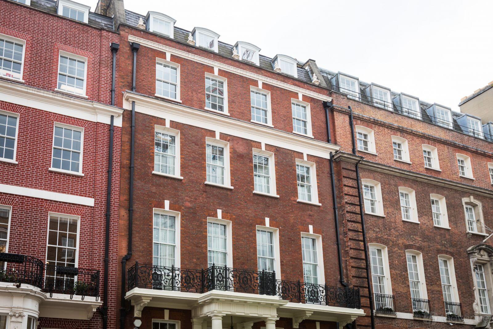 A meeting centre with a red brick facade, tall sash windows, and wrought-iron balconies at The Space Mayfair.
