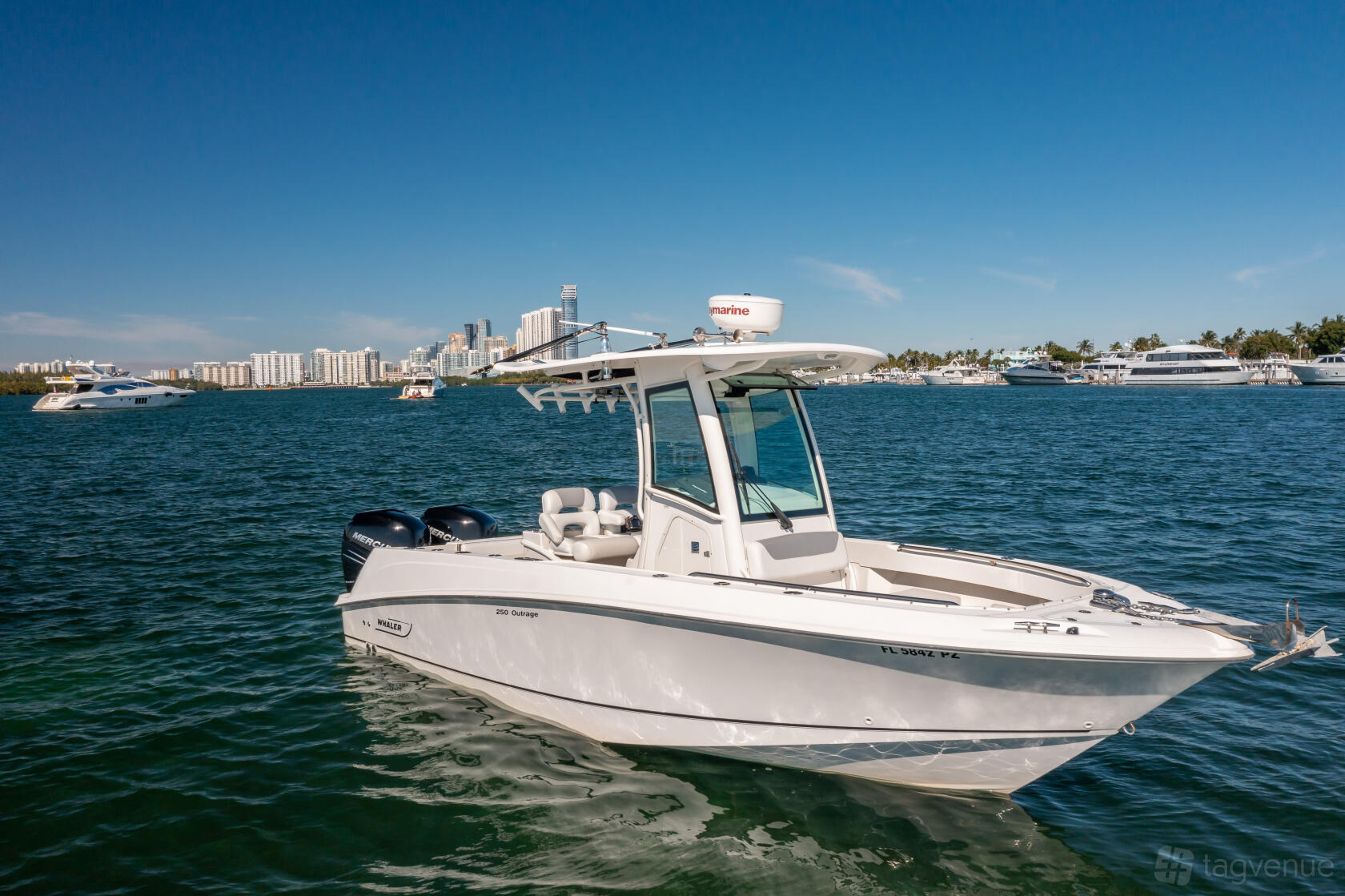 A boat with an open deck, center console and twin outboard engines on the water near Lupo Yachts.