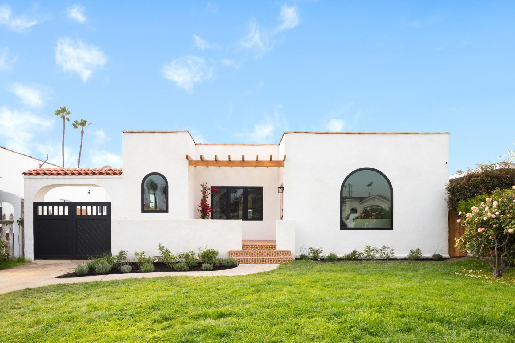A film and photo studio with white stucco exterior, arched windows, and terracotta roof at Sun-Drenched Spanish-Style Abode.