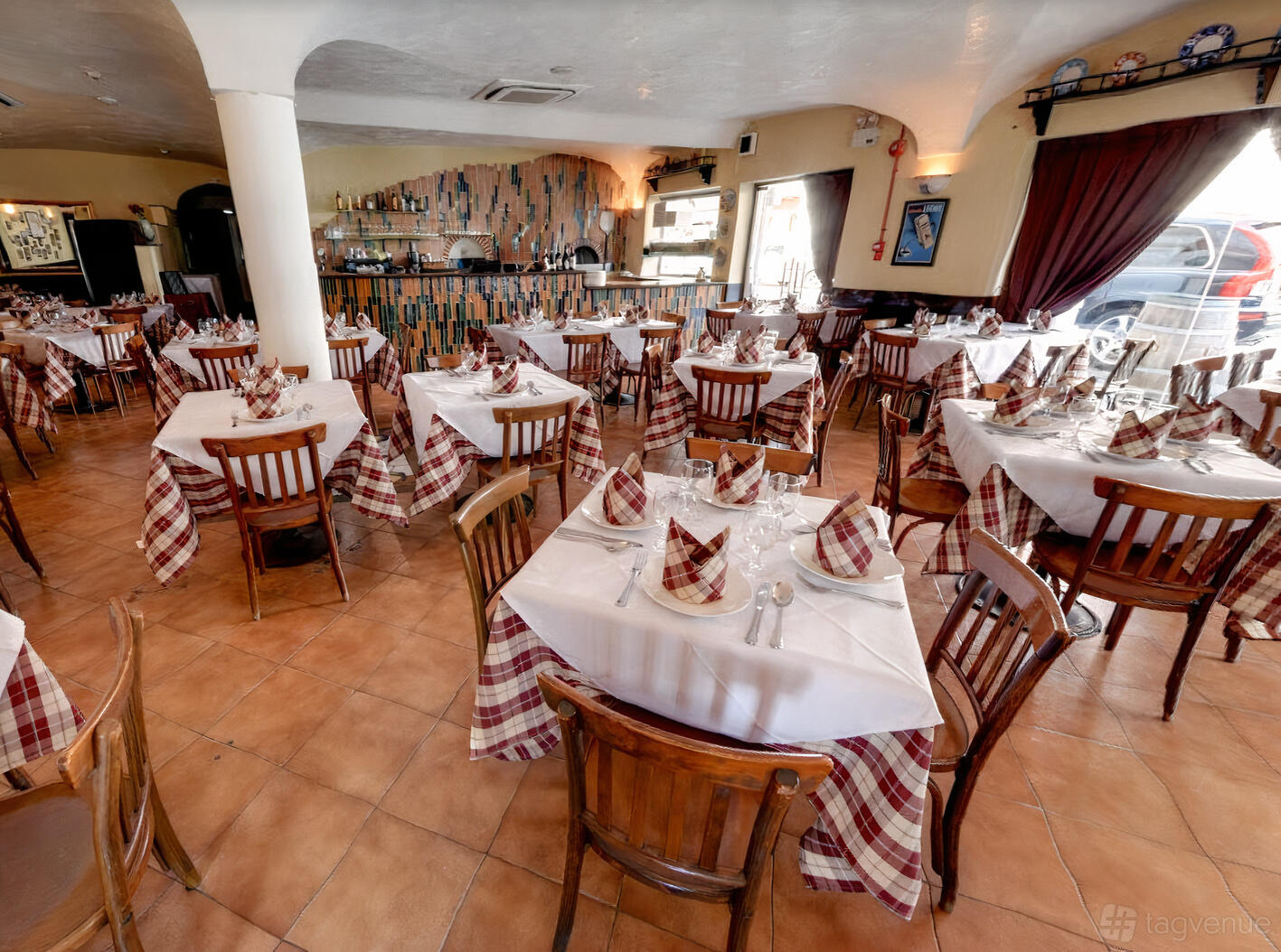 A restaurant dining room with tables draped in checkered linens and wooden chairs at Al Forno (East Coast).