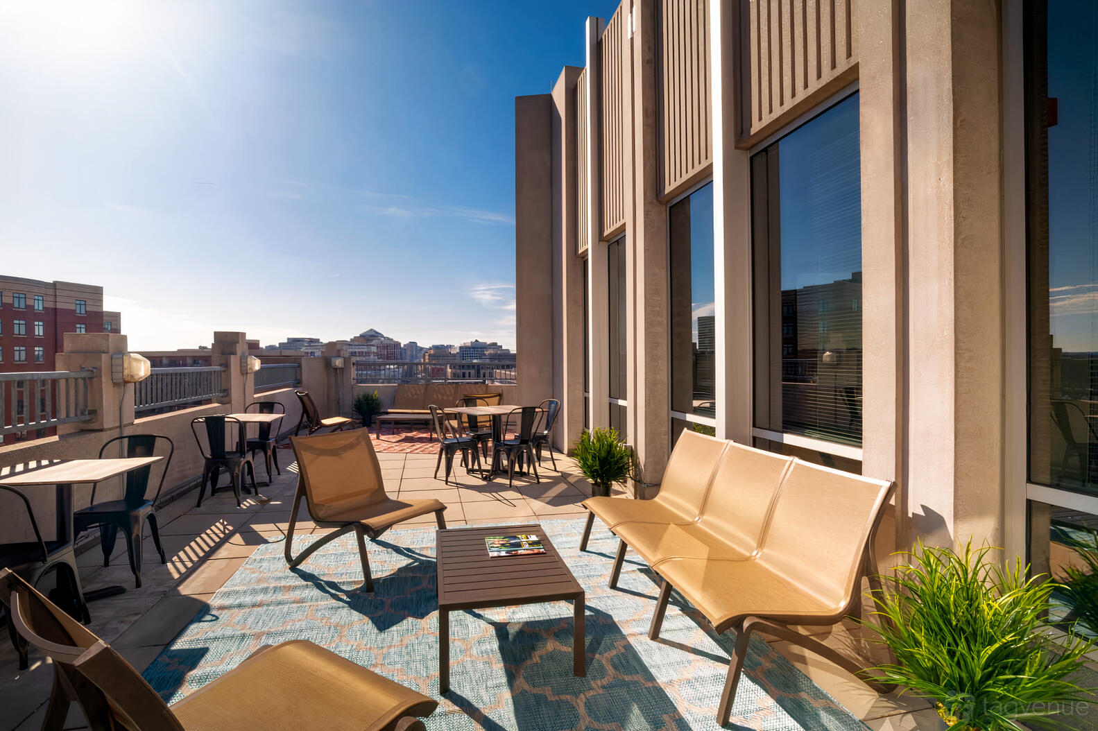 A terrace with lounge seating, potted plants, and city views at Venture X Arlington - Courthouse Metro.