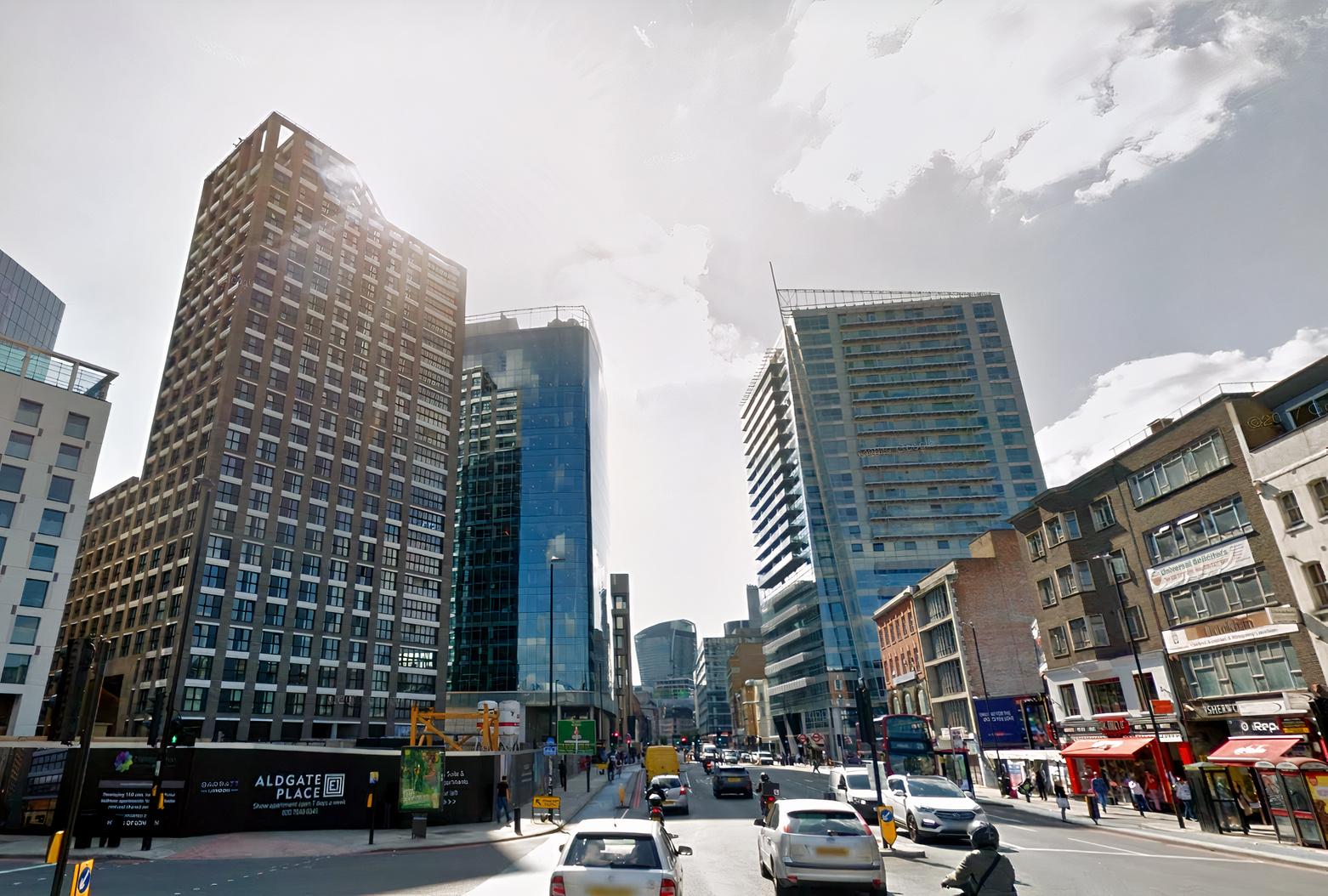 A conference centre surrounded by glass high-rise buildings and busy street traffic near Liverpool St.