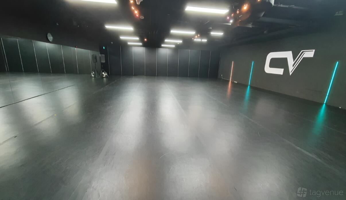 A dance studio with mirrored walls, dark floors, and ceiling strip lighting at Converge Studios Dhoby Ghaut MRT.