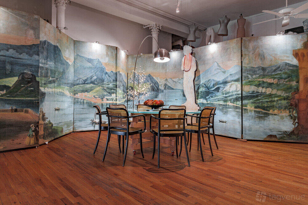 An apartment with painted folding screens, wooden floors, and a dining table with rattan chairs at Casa San Andres.