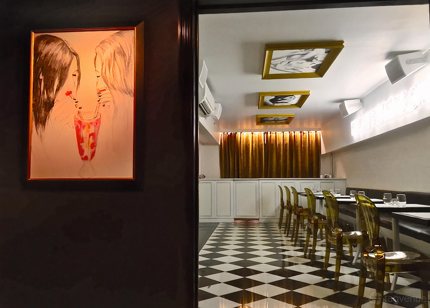A dining room with black and white checkered floors, gold chairs, and framed artwork on the walls at Adoro Lei.