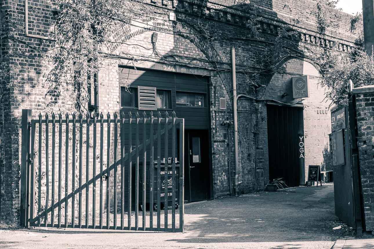 A film and photo studio with exposed brick archways and a metal gate at Arch Photo Studio.