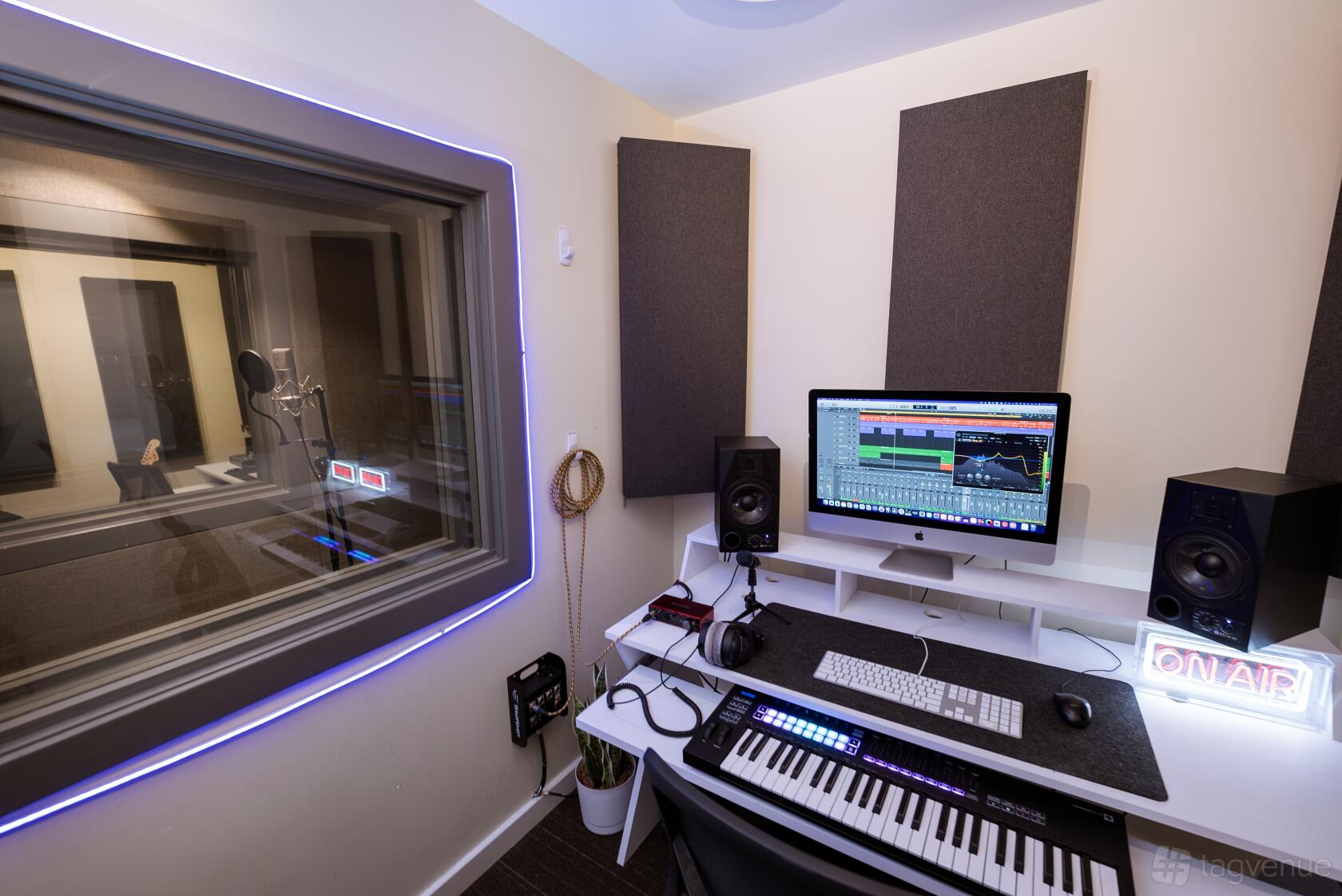 A recording studio with soundproofed walls, a computer workstation, studio monitors, and a keyboard at Brightside Studios.
