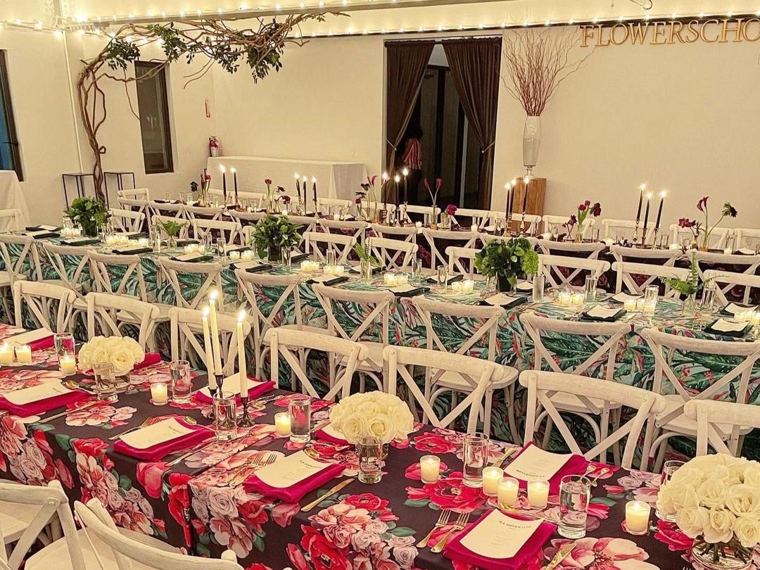 A banqueting hall with long floral-patterned tables, white chairs, and candlelit centerpieces at ILA Penthouse.