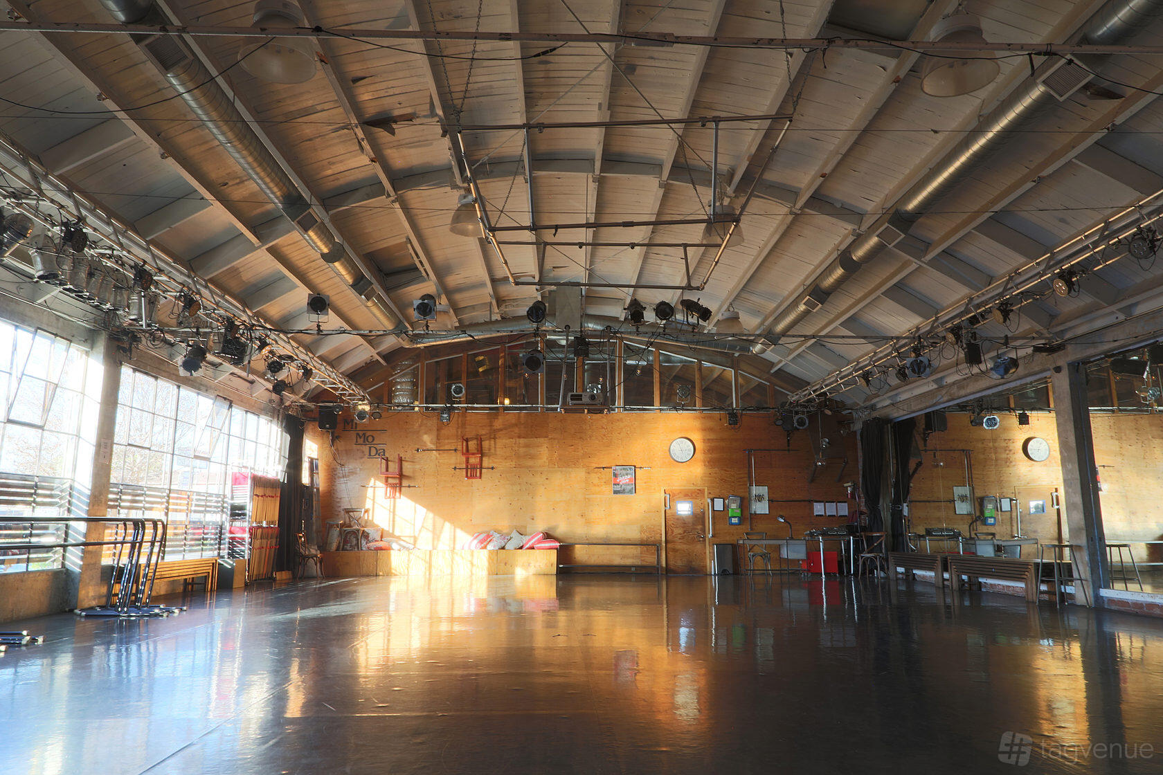 A dance studio with mirrored walls, ballet barres, polished floors, and exposed ceiling beams at Mimoda Studio Theatre.