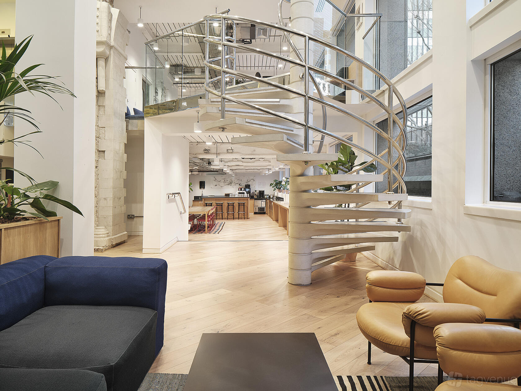 An event venue with a spiral staircase, floor-to-ceiling windows, and lounge seating at Leadenhall Street.