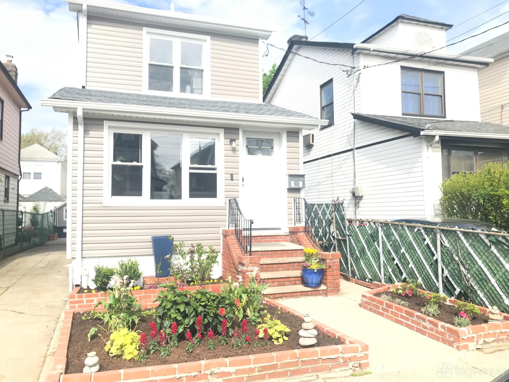 A film and photo studio with a brick entryway, potted plants, and a flower-lined walkway at JRH Productions Inc. @ 48th St