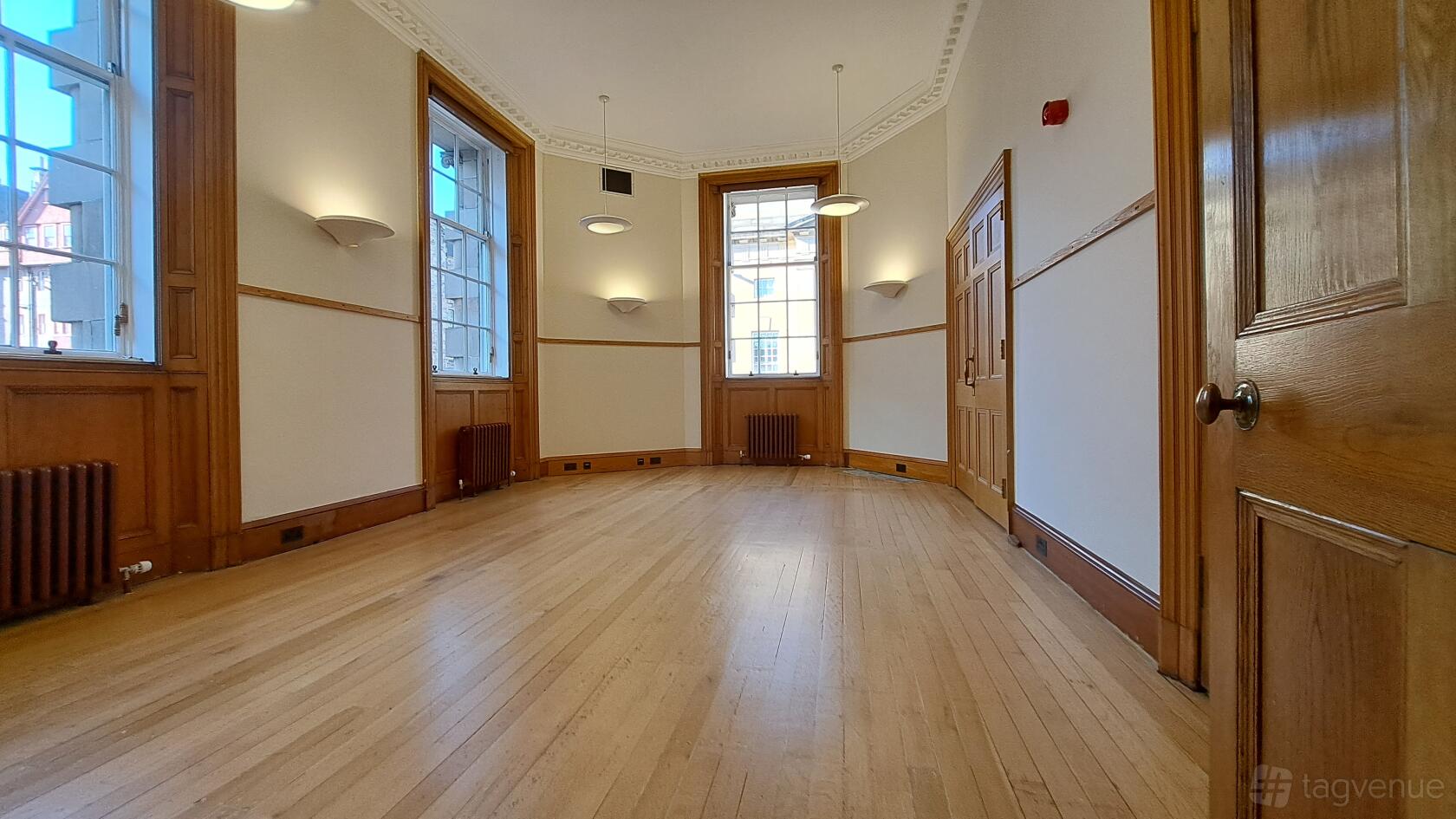 An event space with polished wooden floors, high ceilings, and tall windows at Institut francais d'Ecosse.