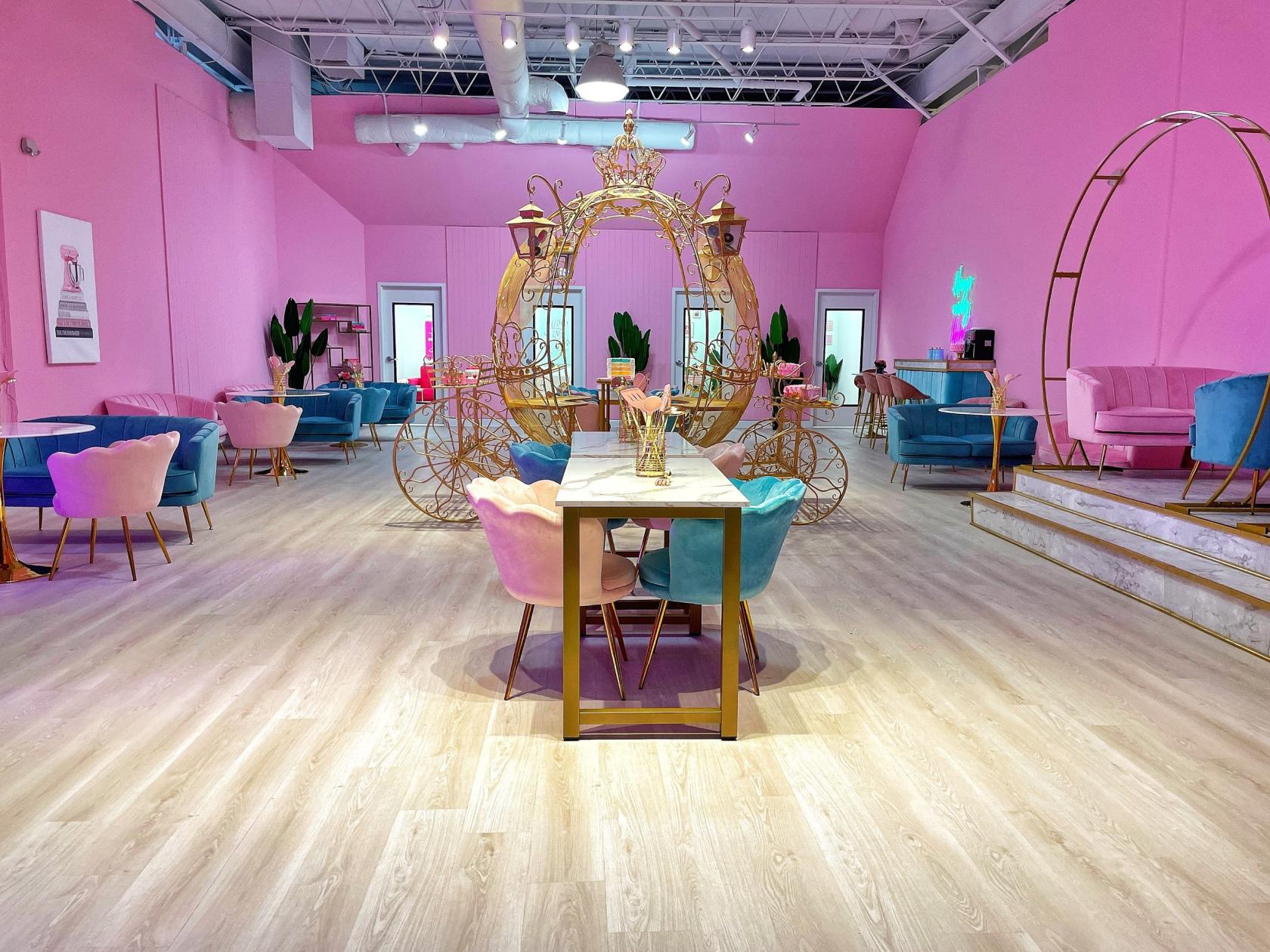 A function room with pastel pink walls, velvet chairs, and decorative gold accents at The Bakery Cowork.