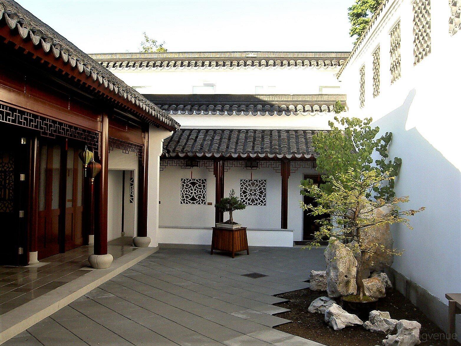 A gallery with traditional Chinese architecture, wooden lattice doors, and a courtyard garden at Dr. Sun Yat-Sen Classical Chinese Garden.