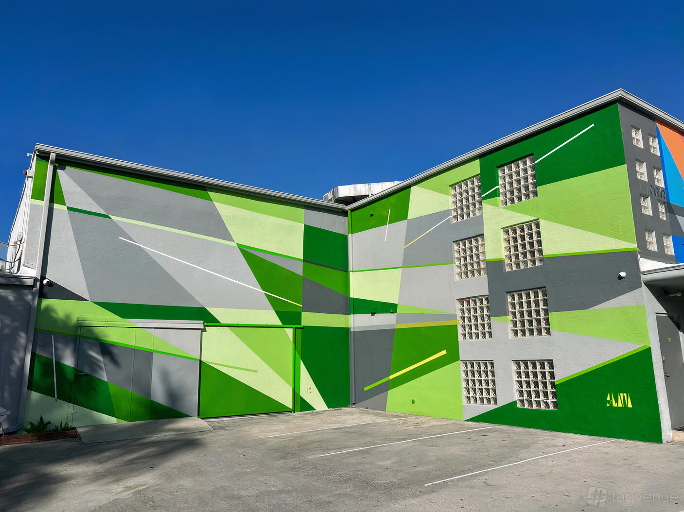 A film and photo studio with a vibrant geometric mural in green shades on the exterior wall at Grove Studios.