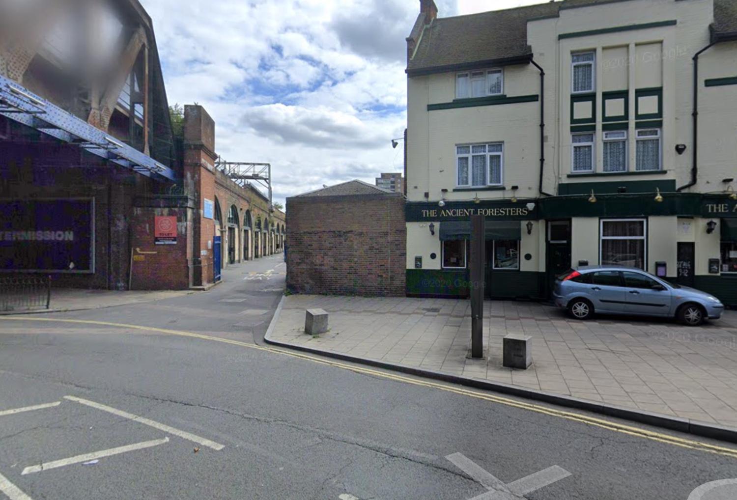 A versatile event space with a white-painted exterior and adjacent brick railway arches at Bermondsey Social Club.