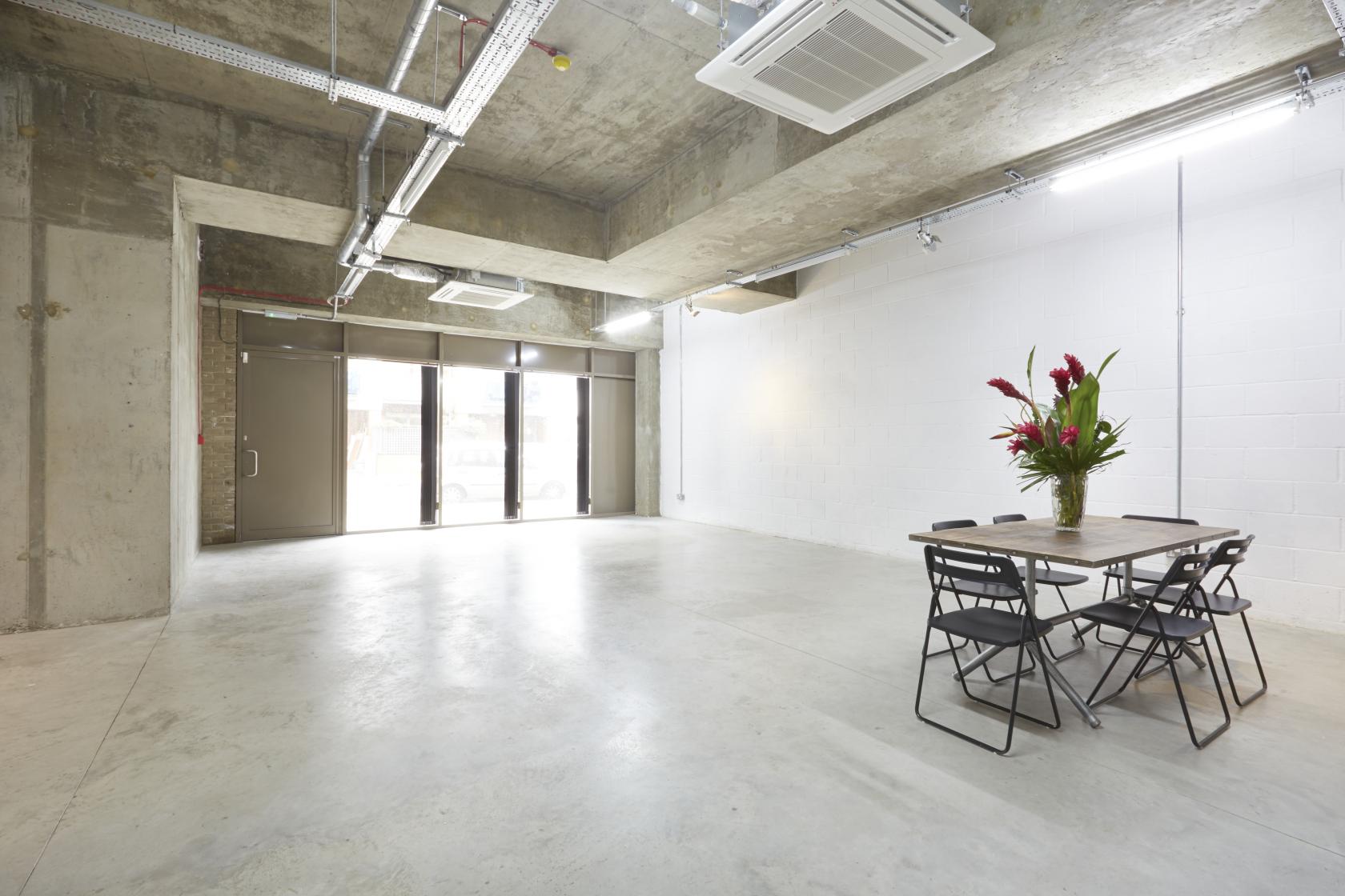 A blank canvas event venue with concrete floors, exposed ceilings, and large windows at LOCK Studios.