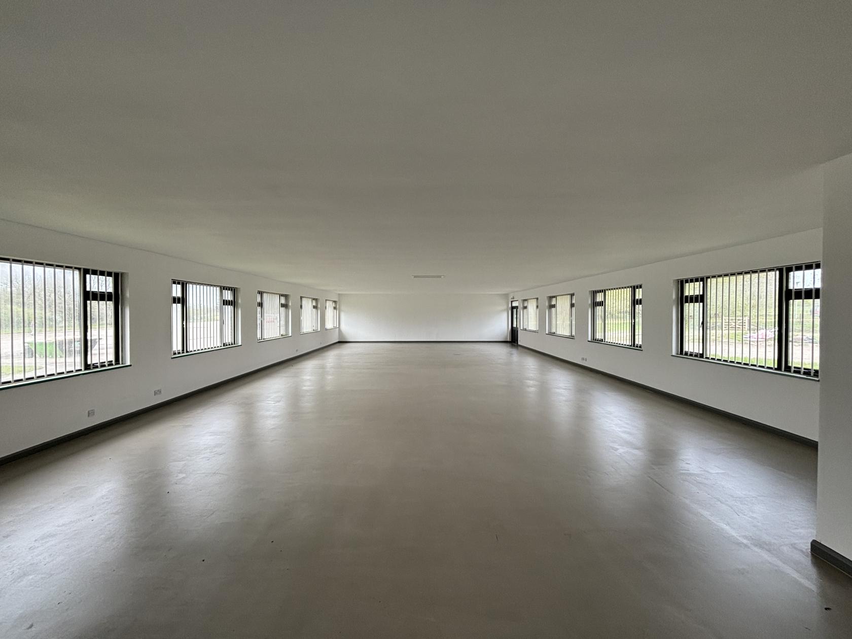 An event venue with large windows, neutral flooring, and ample natural light at Thoulstone Park.