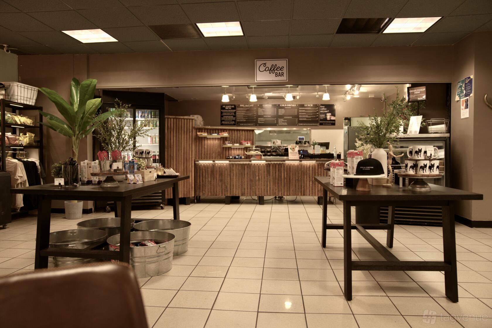 A cafe with tiled floors, wooden tables, and a counter displaying pastries at Stella Coffee.