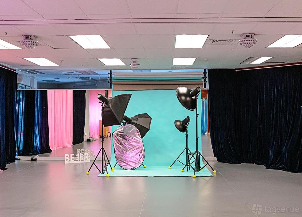 A dance studio with photography lighting equipment, backdrop, and mirrored walls at BE Studio.