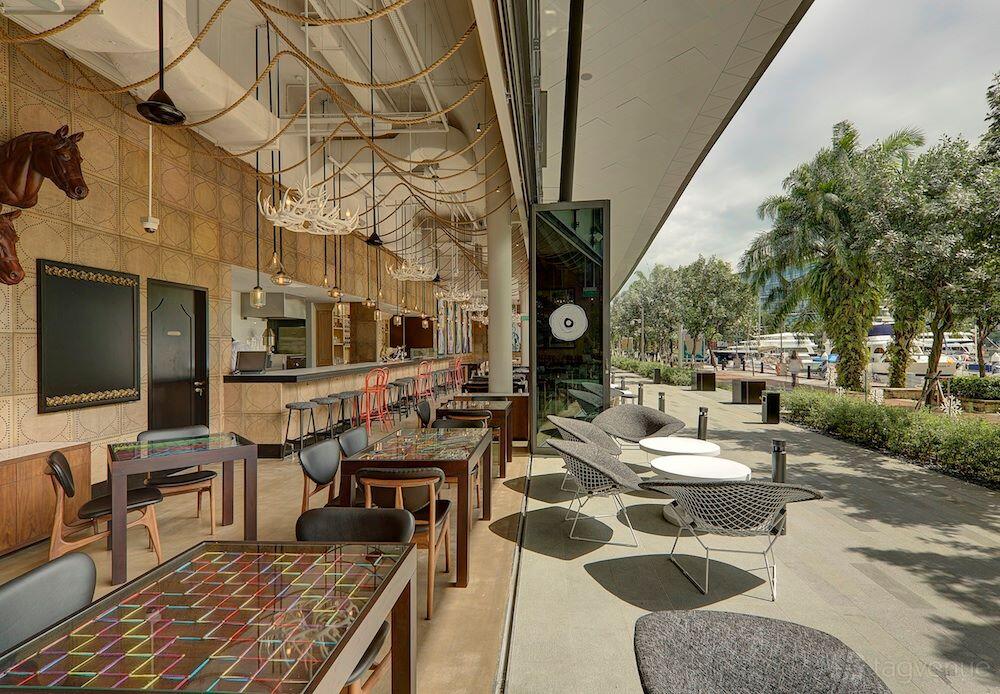 A restaurant with open-air seating, colorful tiled tables, and marina views at Sabio by the Sea.