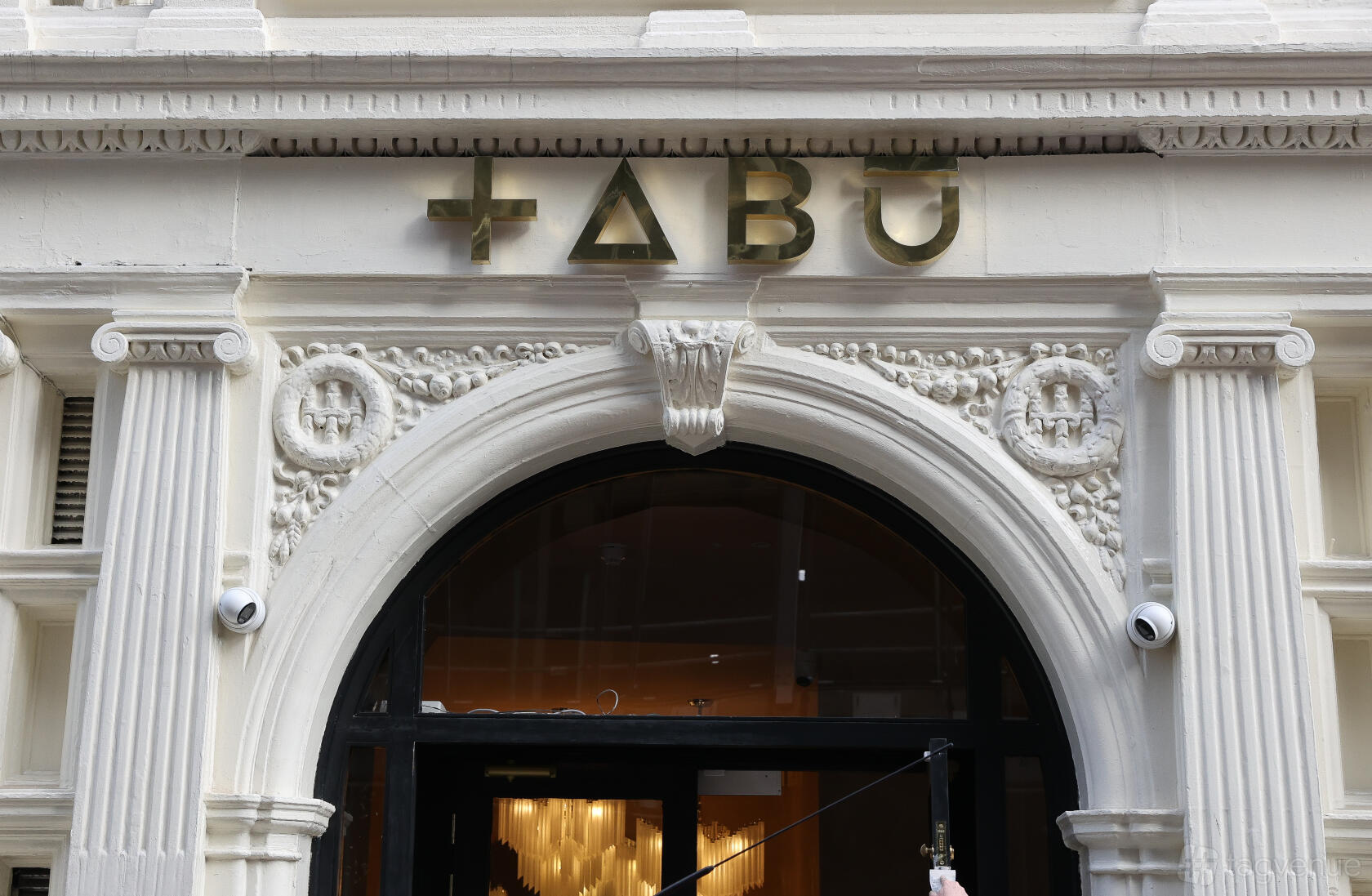 A nightclub entrance with ornate white columns and gold signage at Tabu London.