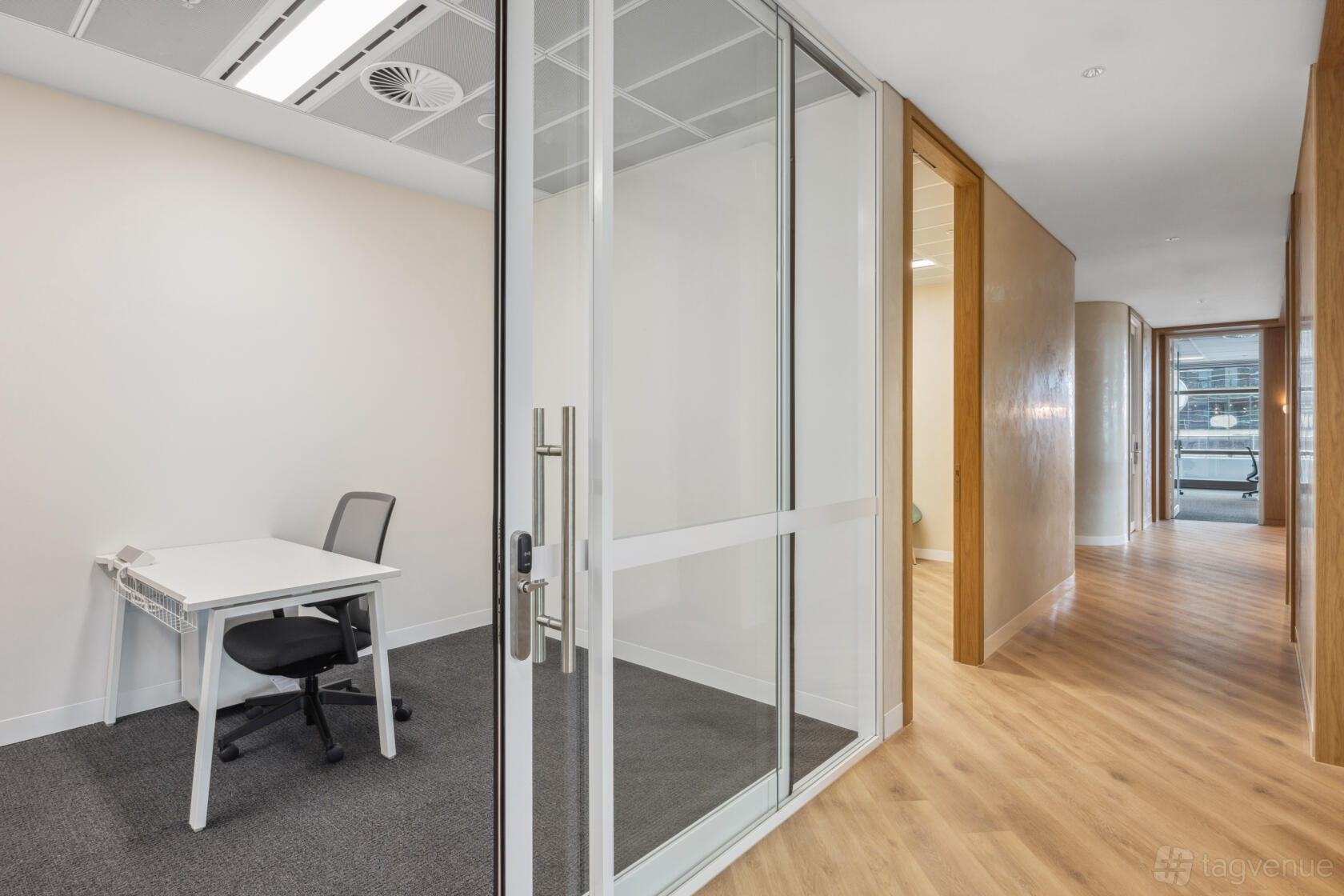 An office space with glass walls, a white desk, and ergonomic chair at The Work Project at 100 Arthur Street.