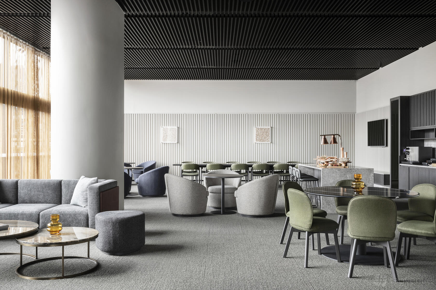 A hotel lounge with green upholstered chairs, round marble tables, and floor-to-ceiling windows at Oakwood Premier Melbourne.