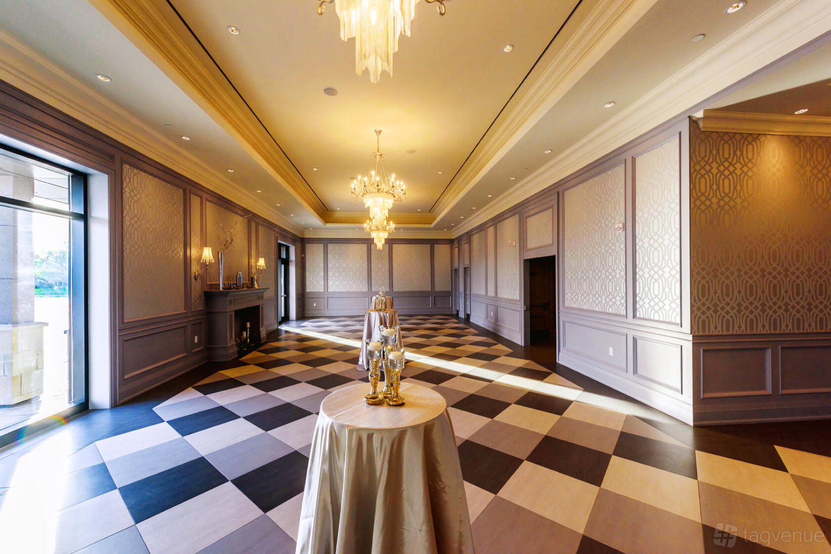 An event space with checkered tile floors, chandeliers, and decorative wall paneling at Parkview Manor.