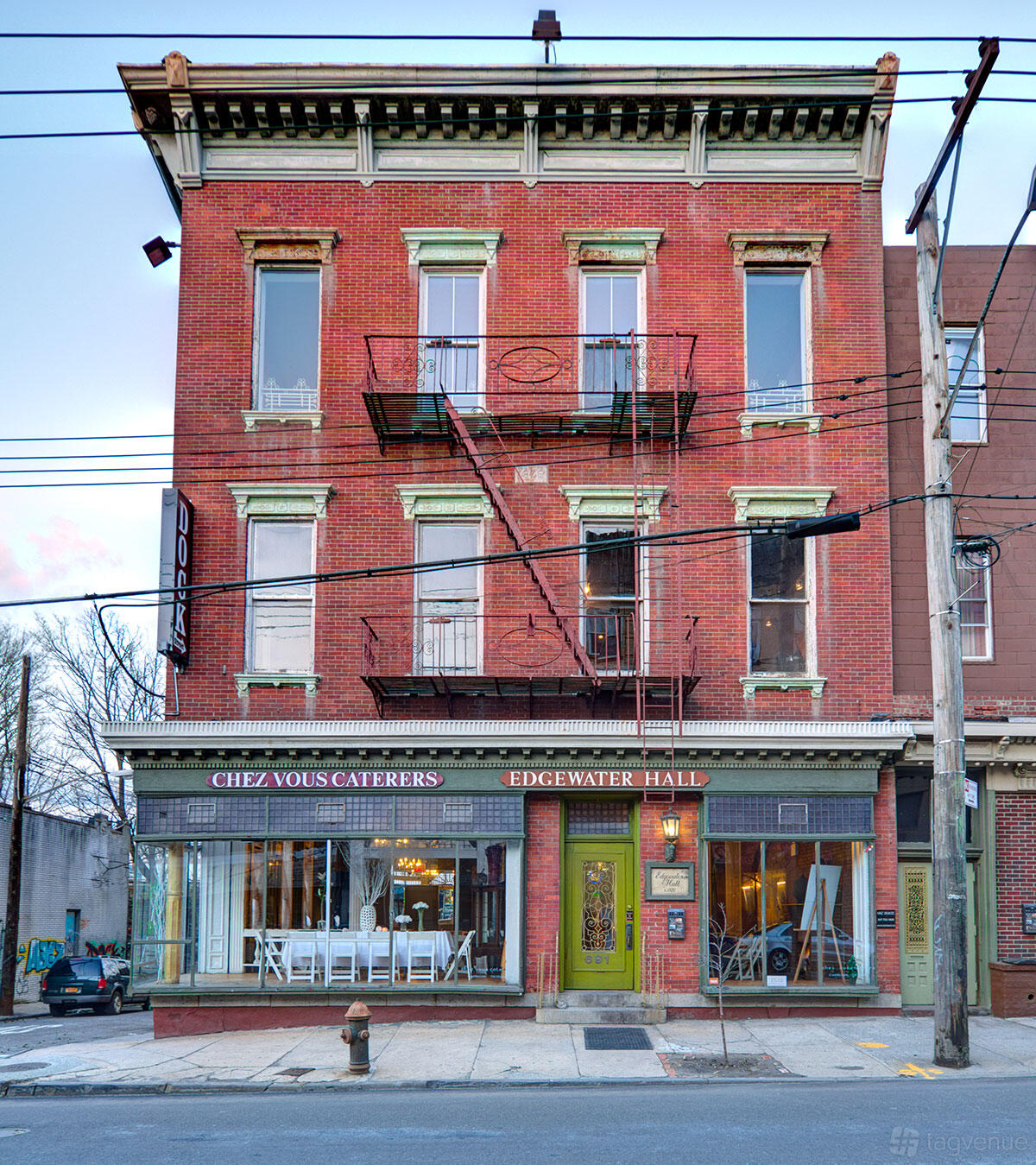 A red brick building with large windows and wrought iron balconies at Edgewater Hall.