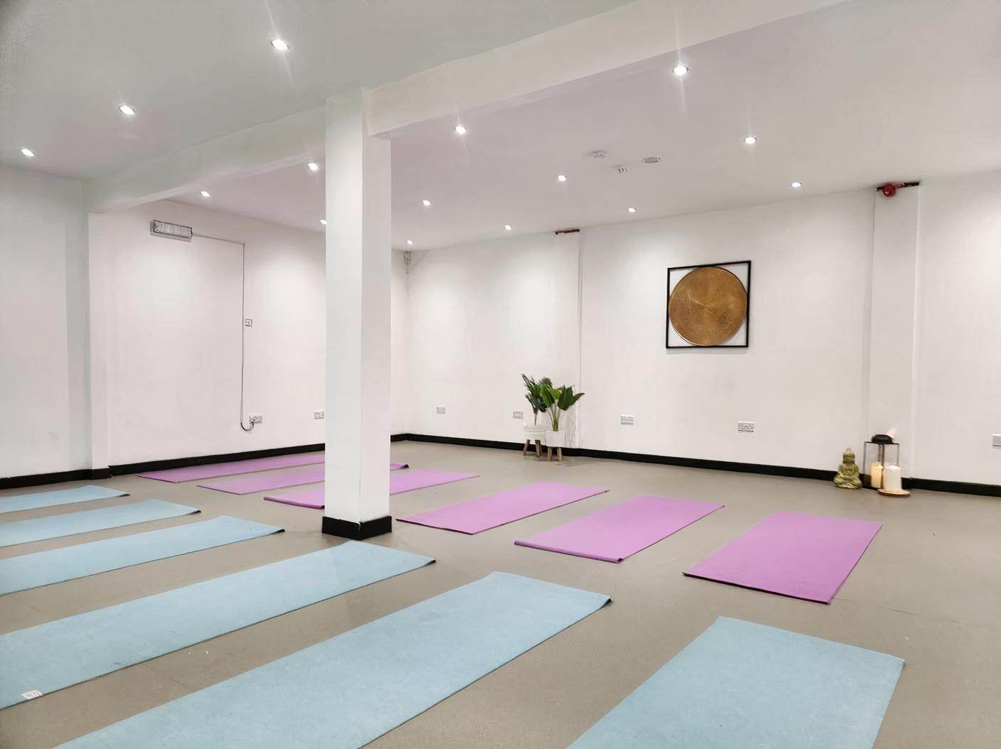 An event venue with yoga mats arranged on a light floor, white walls, and recessed lighting at NO 36.