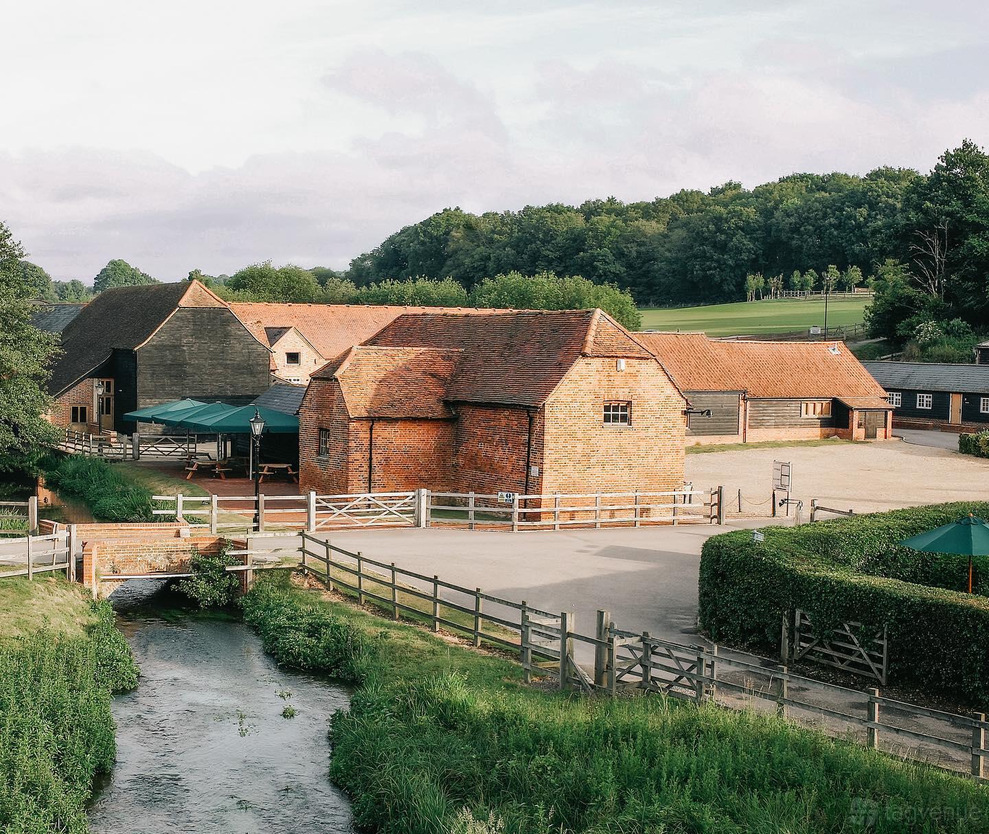 A hotel with rustic brick buildings, red tiled roofs, and open courtyard at Tewinbury Farm Hotel