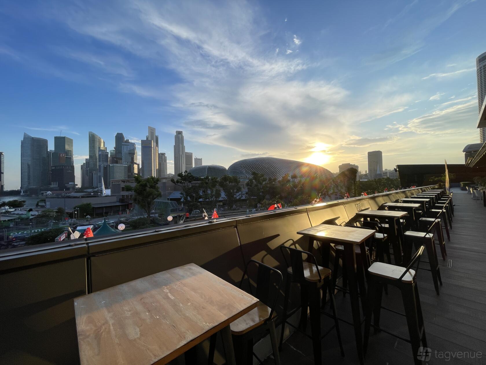 An outdoor dining area with high tables, chairs, and skyline views at Tenkaichi Japanese Restaurant.