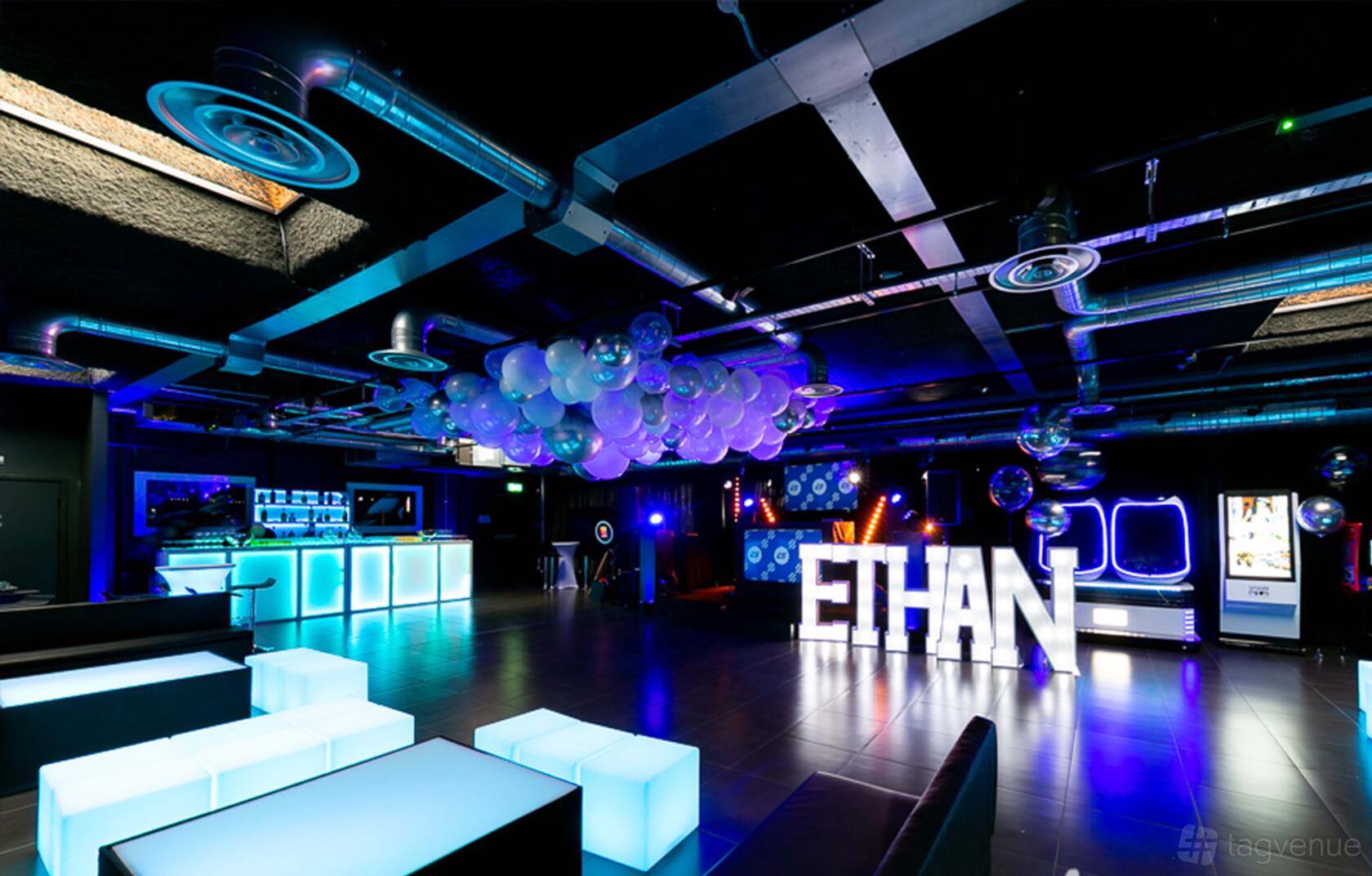 An event venue with illuminated furniture, exposed ductwork, and decorative balloons at The Engine Rooms Events Space.
