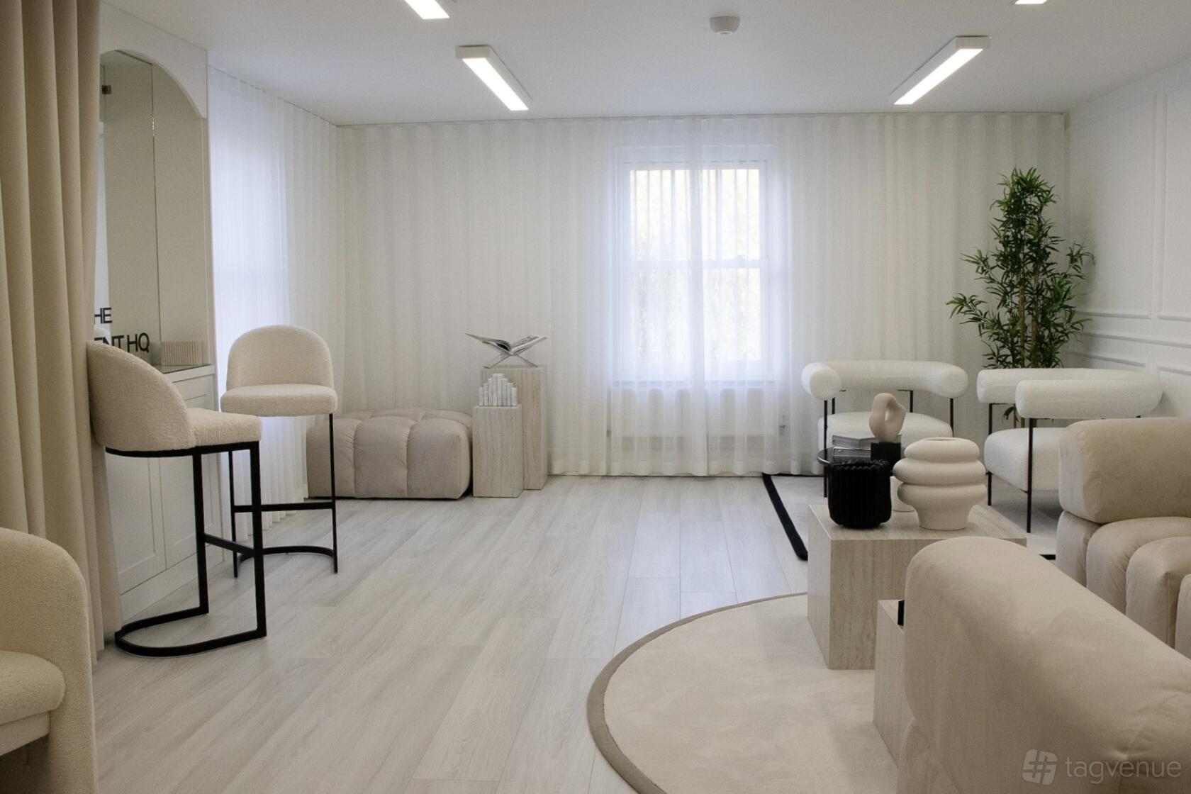 A photo and film studio with white walls, modern lounge seating, and sheer curtains at The Content HQ.