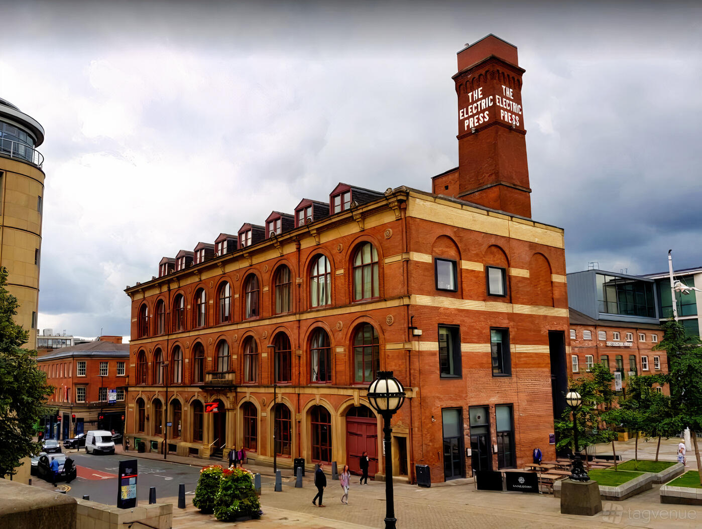 A red-brick event venue with arched windows and a distinctive clock tower at Revolution Leeds Electric Press.
