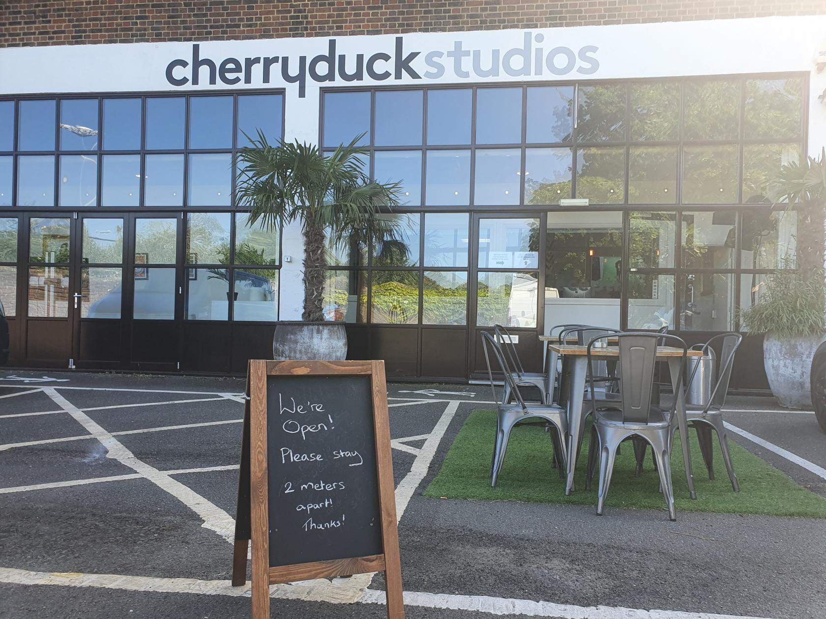 A film and photo studio with large glass windows, palm trees, and outdoor seating at Tower Bridge Studios.