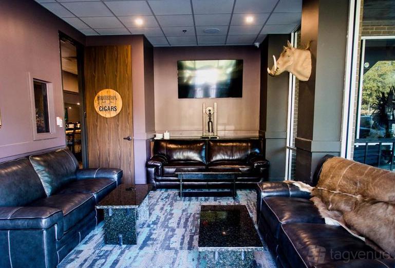 A lounge with dark leather sofas, animal decor, and a mounted TV at Mirage 38.