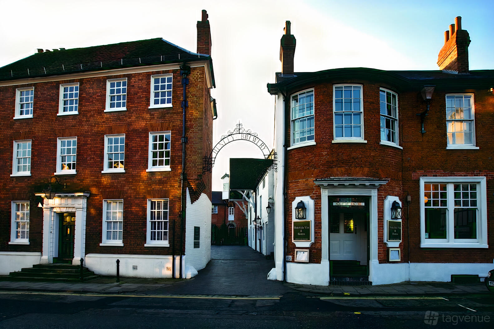 A red brick hotel with white-framed windows and an arched iron entrance at Hotel du Vin Henley-on-Thames.