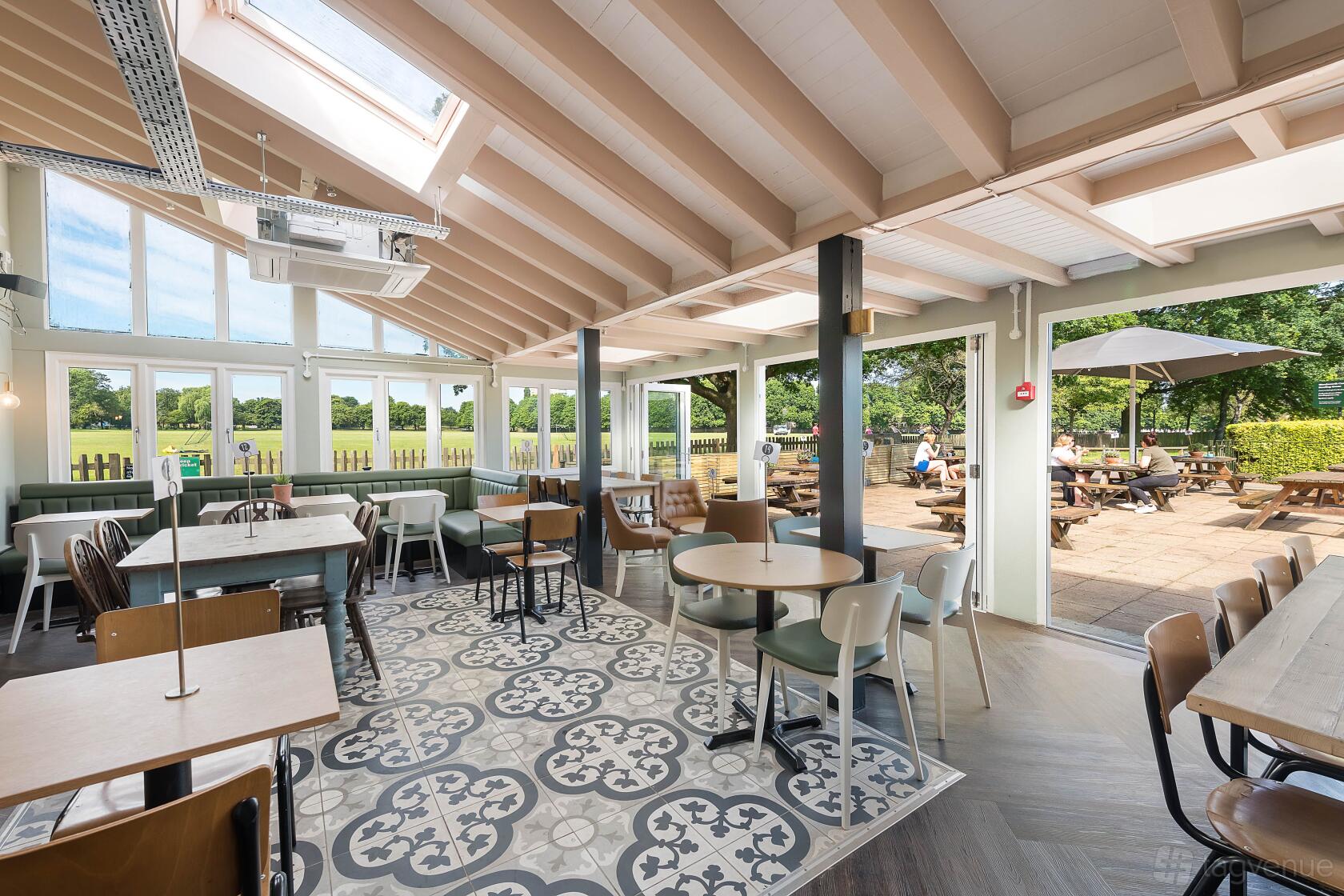 A cafe with patterned tile flooring, large windows, and outdoor seating area at The Skylark cafe.