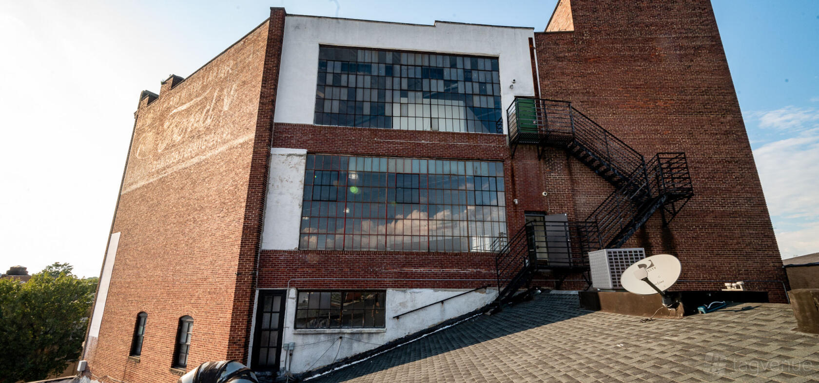 A versatile event space with large industrial windows and an exterior metal staircase at Crave Cave.