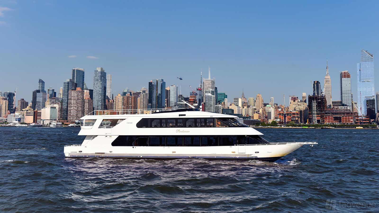 A white yacht cruising on the water with a city skyline in the background at Del Rio Yacht Charter.