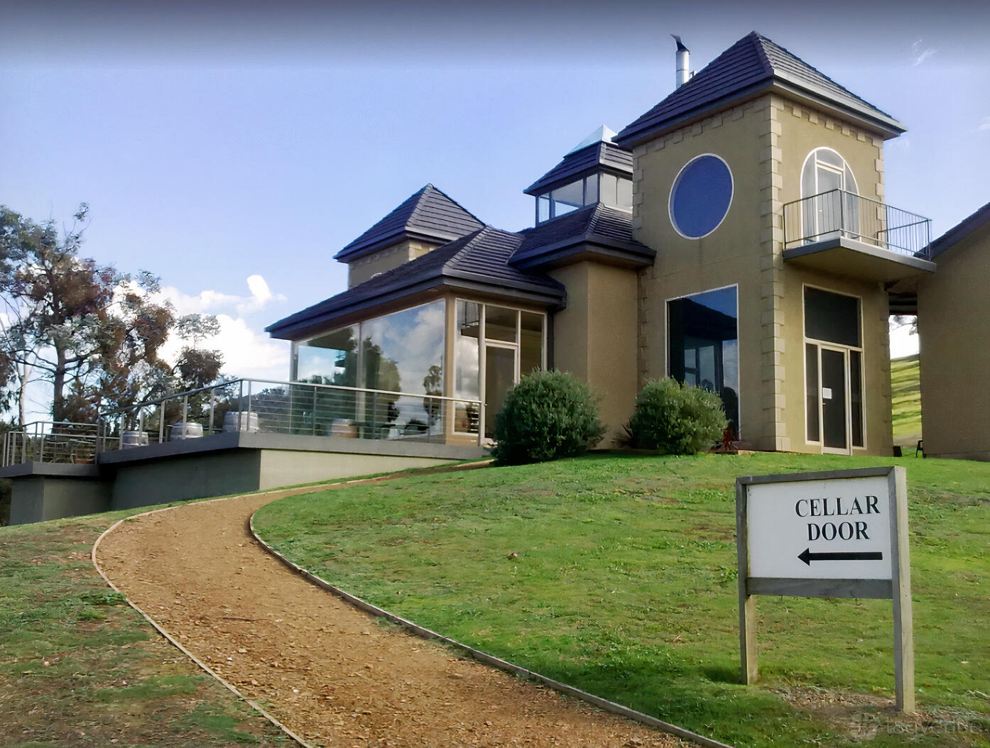 A country house with large windows, a wraparound patio, and manicured lawn at Sutherland Estate.