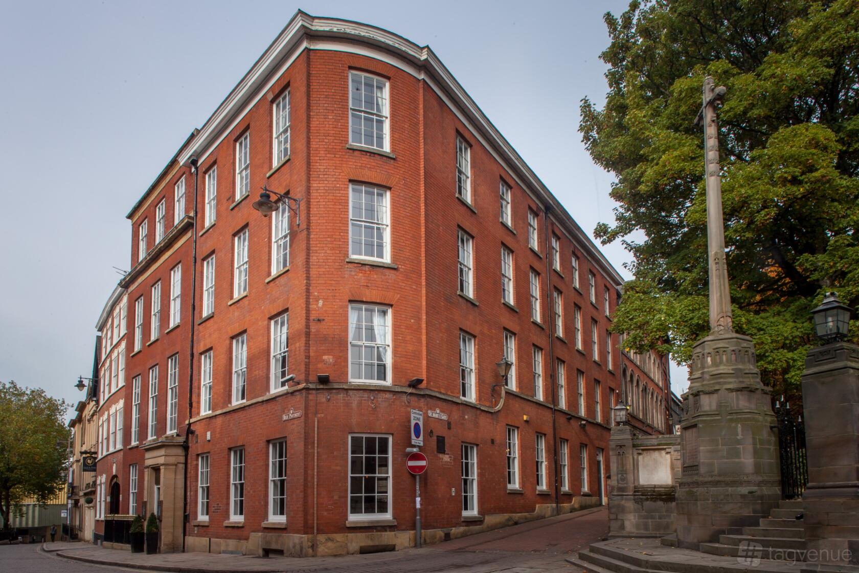 A red brick hotel with large sash windows and a corner entrance at Lace Market Hotel.