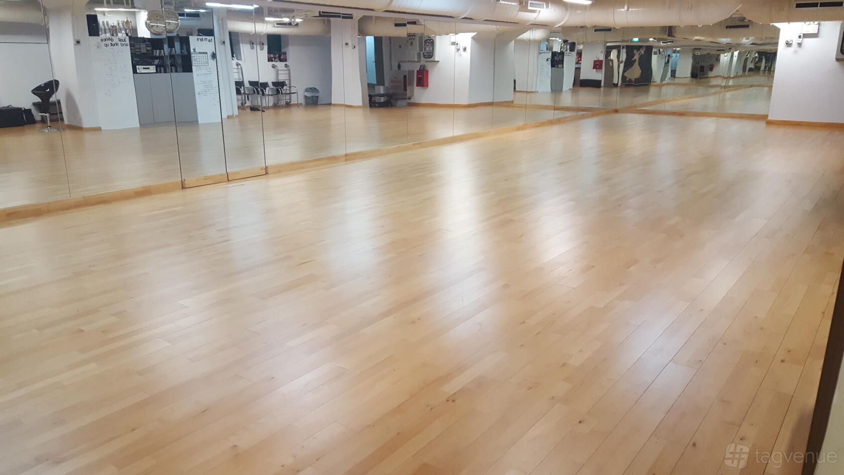 A dance studio with a polished wooden floor and wall-length mirrors at Melvyn Low Dance Studio.
