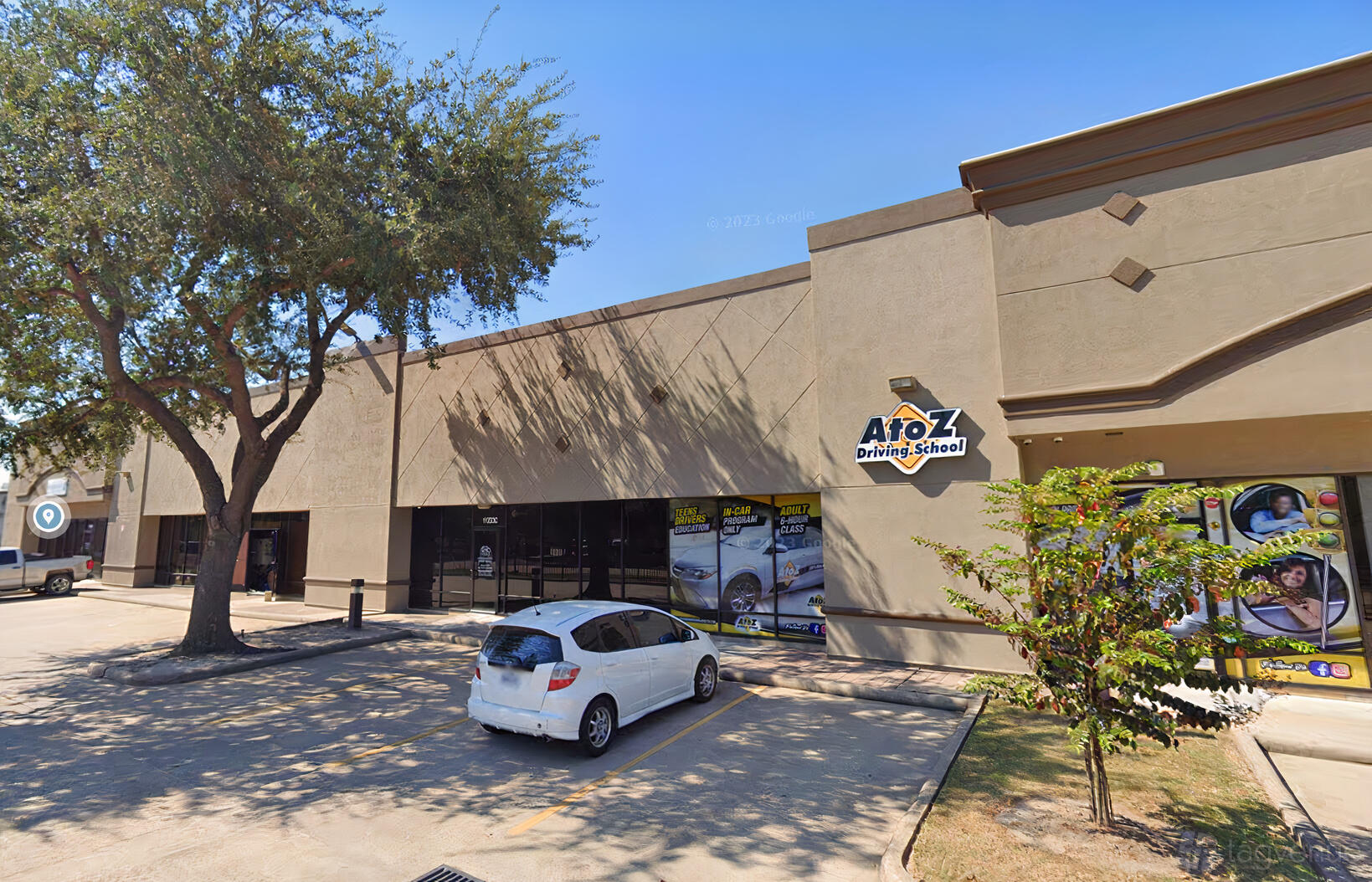 A versatile event space with a flat-roof building, tall windows, and parking lot at Venue 5683.