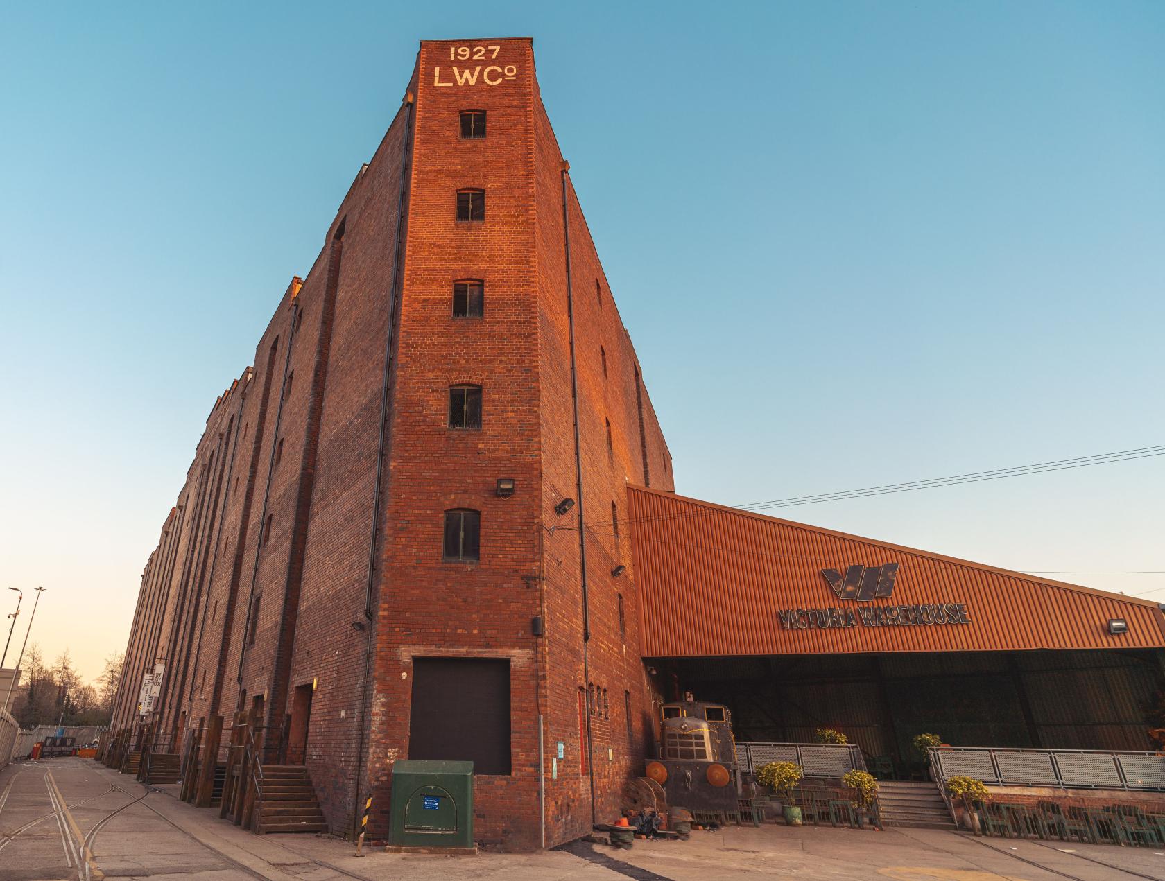 An industrial event space with red brick exterior and large warehouse entrance at Victoria Warehouse.