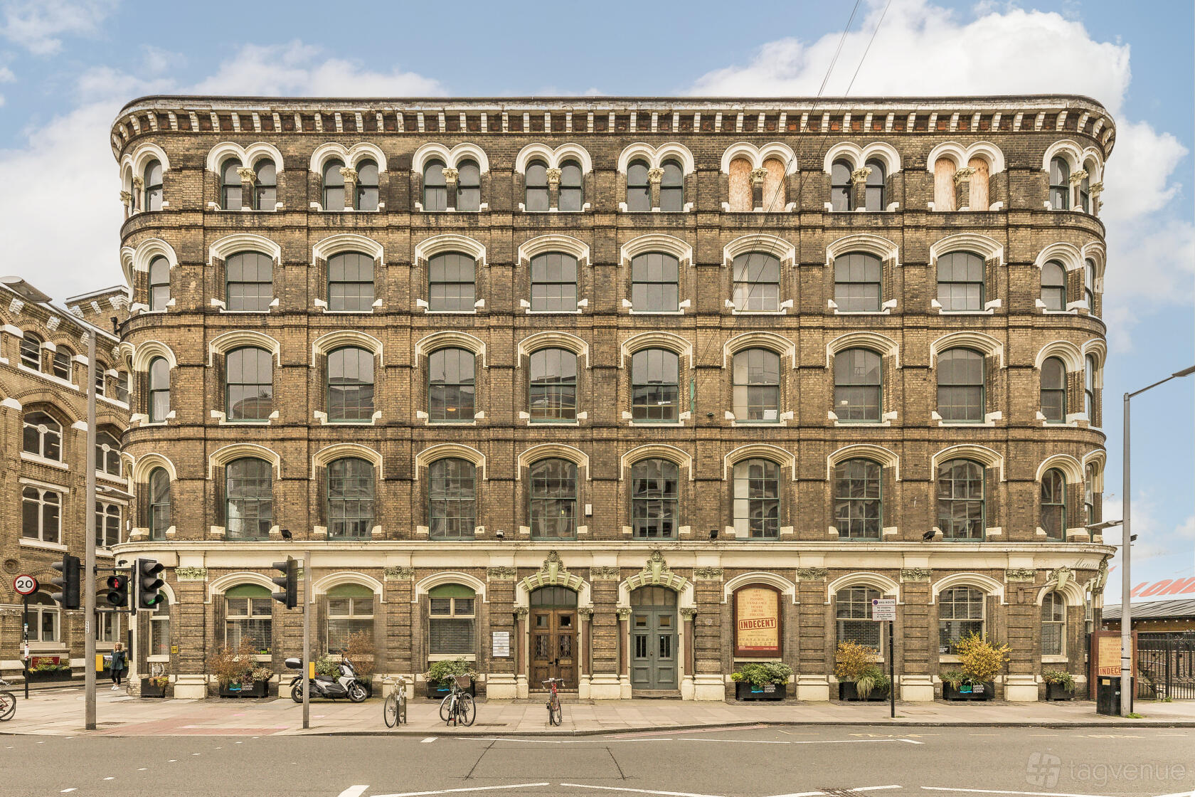 A historic brick building with arched windows and green accents at Menier Lounge.