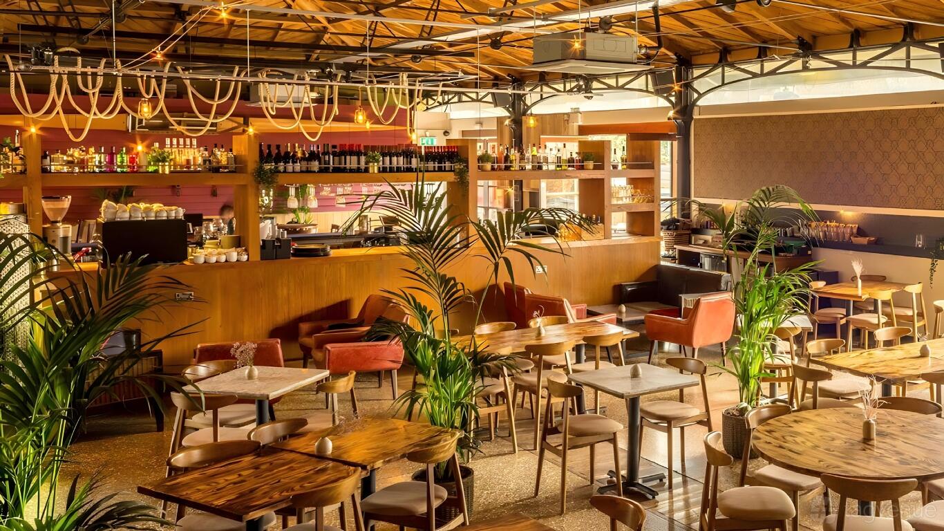 A restaurant with wooden tables, velvet chairs, potted plants, and a central bar at Harbour House.